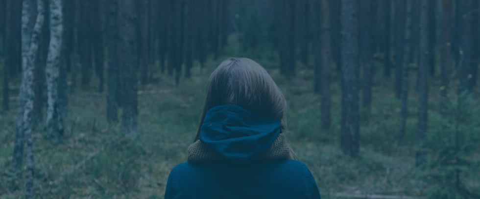 woman walking in dark woods