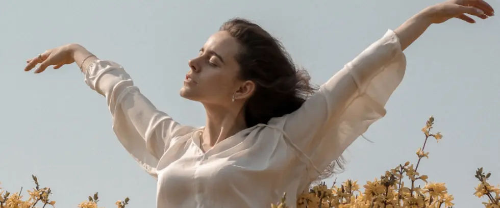 Woman in a field enjoying the sun and weather