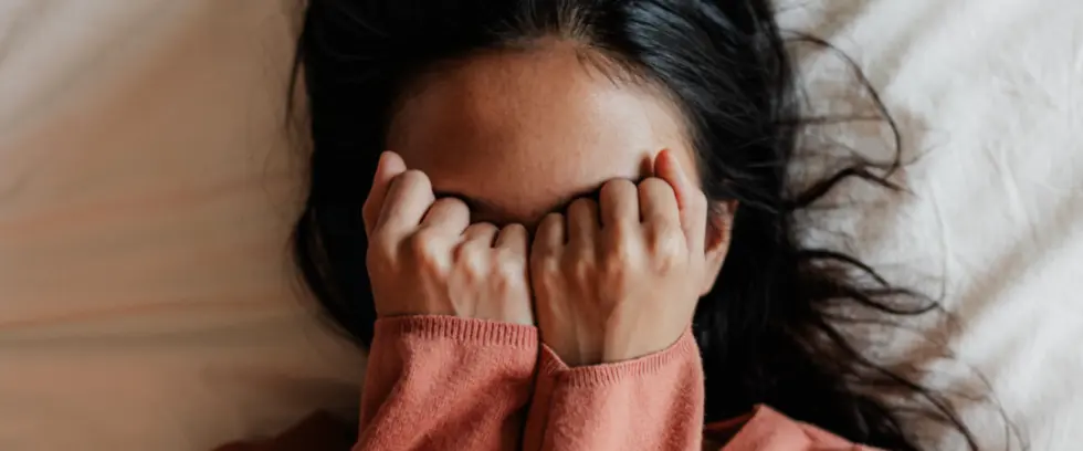 Woman laying in bed in frustration