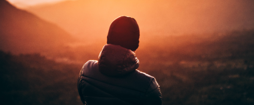 Person looking at mountains as the sun sets