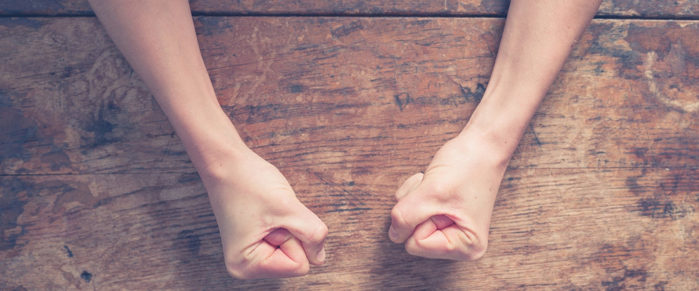 Person clenching their fists in anger